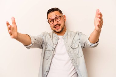 Latin kökenli genç bir adam zaferi ya da başarıyı kutlarken beyaz arka planda mahsur kaldı. Şaşırdı ve şok oldu..