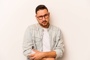 Beyaz arka planda izole edilmiş genç İspanyol adam alaycı bir ifadeyle kameraya bakıyor..