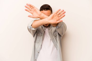 Beyaz arka planda izole edilmiş genç İspanyol adam iki kolu çapraz tutuyor, inkar kavramı.