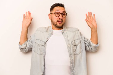 Beyaz arka planda izole edilmiş genç bir İspanyol, yakın bir tehlike nedeniyle şok oluyor.