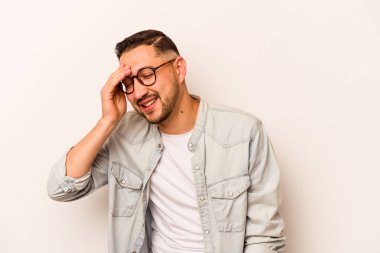 Genç İspanyol adam beyaz arka planda izole edilmiş neşeli bir şekilde gülüyor. Mutluluk kavramı.