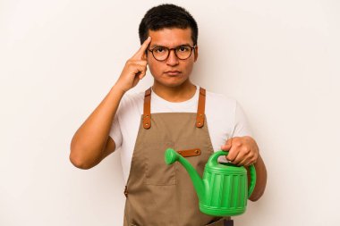 Genç bahçıvan, elinde su dolu bir teneke tutarak tapınağı parmağıyla işaret ederek bir göreve odaklanmış..