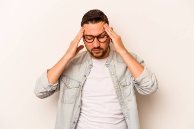 Beyaz arka planda izole edilmiş genç İspanyol bir adamın başı ağrıyor, yüzüne dokunuyor..