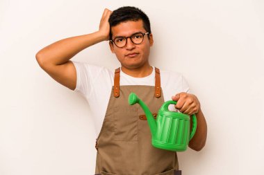 Genç bahçıvan elinde su bidonu tutan İspanyol beyaz arka planda izole edilmiş, şoka uğrayan, önemli bir toplantıyı hatırladı..