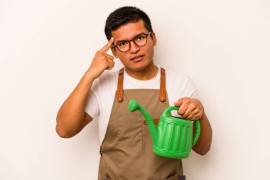 Genç bahçıvan İspanyol bir adam beyaz arka planda izole edilmiş bir su bidonu tutuyor işaret parmağıyla hayal kırıklığı jesti gösteriyor..