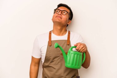 Genç bahçıvan, elinde su dolu bir teneke tutarak beyaz arka planda amaçlarına ve amaçlarına ulaşmayı düşlüyor.