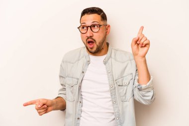 Beyaz arka planda izole edilmiş genç İspanyol adam farklı kopya alanlarını gösteriyor, birini seçiyor, parmaklarıyla gösteriyor..