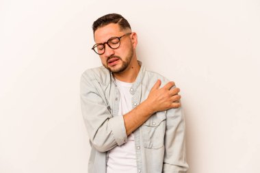 Beyaz arka planda izole edilmiş genç İspanyol bir adam omuz ağrısı çekiyor..