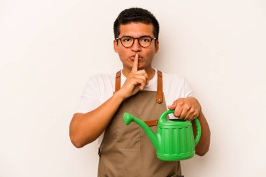 Genç bahçıvan, elinde bir su bidonu olan İspanyol bir adam beyaz arka planda izole edilmiş bir şekilde sır saklıyor ya da sessizlik istiyor..