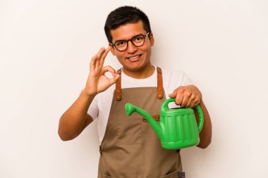 Genç bahçıvan İspanyol bir teneke su tutuyordu. Beyaz arka planda izole edildi. Neşeli ve kendinden emin..