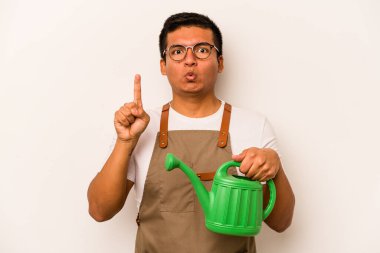 Genç bahçıvan İspanyol bir adam beyaz arka planda su dolu bir teneke kutu tutuyor. Harika bir fikri var, yaratıcılık kavramı..