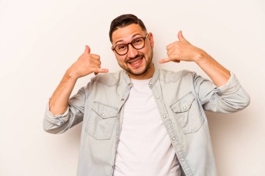 Beyaz arka planda izole edilmiş genç bir İspanyol, parmakları olan bir cep telefonu hareketi gösteriyor..