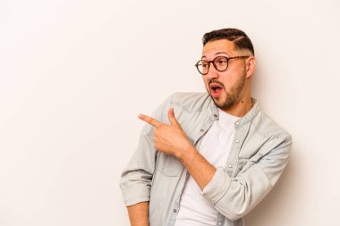 Beyaz arka planda soyutlanmış genç İspanyol adam gülümseyen, neşeli ve keyifli bir kenara bakıyor..