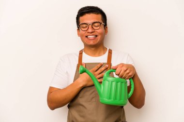 Genç bahçıvan, beyaz arka planda izole edilmiş bir su bidonu tutan İspanyol adam kahkahalarla gülüyor..