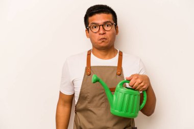 Genç bahçıvan İspanyol bir teneke su tutuyordu. Beyaz arka planda izole edilmiş, omuzlarını silkti ve gözleri açıktı..