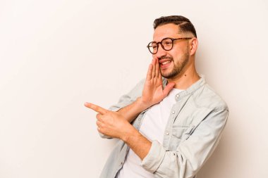 Latin kökenli genç bir adam beyaz arka planda izole edilmiş. Dedikodu yapıyor, bir şeyleri bildiriyor..