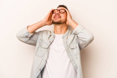 Beyaz arka planda izole edilmiş genç İspanyol adam ellerini başının üstünde tutarak neşeyle gülüyor. Mutluluk kavramı.