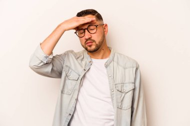 Beyaz arka planda izole edilmiş genç İspanyol adam tapınaklara dokunuyor ve baş ağrısı çekiyor..