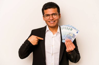 Latin kökenli genç bir iş adamı, elinde banknotlar tutan, beyaz arka planda yaşayan, gömlek fotokopi alanını gösteren, gururlu ve kendinden emin bir adam.