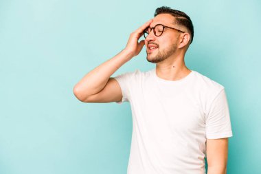 Genç İspanyol adam mavi arka planda izole edilmiş gülerek, kaygısızca, doğal duygularla.