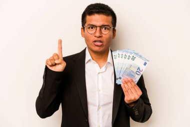 Latin kökenli genç bir iş adamı beyaz arka planda izole edilmiş banknotlar tutuyor. Bir fikri, ilham konsepti var..