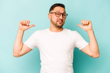 Mavi arka planda izole edilmiş genç bir İspanyol gururlu ve kendinden emin hissediyor, örnek olarak..