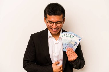 Genç İspanyol iş adamı banknotları tutuyor, beyaz arka planda izole edilmiş gülüyor ve eğleniyor..