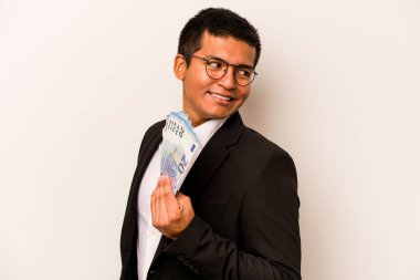 Beyaz arka planda soyutlanmış banknotları tutan genç İspanyol iş adamı gülümseyen, neşeli ve keyifli bir kenara bakıyor..