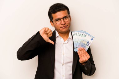 Latin kökenli genç bir iş adamı beyaz arka planda izole edilmiş banknotlar tutuyor. Hoşlanmadığı bir hareket gösteriyor. Anlaşmazlık konsepti.
