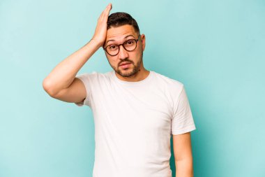 Mavi arka planda izole edilmiş genç bir İspanyol şoka uğruyor, önemli bir buluşmayı hatırlıyor..