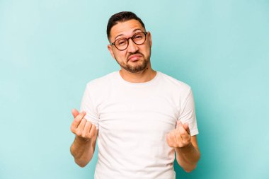 Genç İspanyol adam mavi arka planda izole edilmiş, parasız olduğunu gösteriyor..