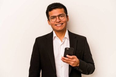 Beyaz arka planda izole edilmiş, mutlu, güler yüzlü ve neşeli bir şekilde cep telefonu tutan genç bir İspanyol iş adamı..