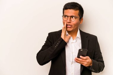 Beyaz arka planda izole edilmiş cep telefonu tutan İspanyol genç adam gizli bir sıcak fren haberi veriyor ve yana bakıyor