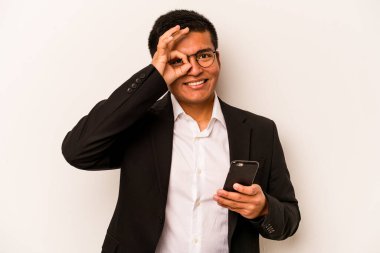 Beyaz arka planda izole edilmiş cep telefonu tutan genç bir İspanyol iş adamı heyecanlı..