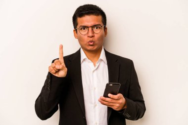 Genç İspanyol iş adamı cep telefonunu beyaz arka planda izole ediyor. Harika bir fikri var, yaratıcılık kavramı..