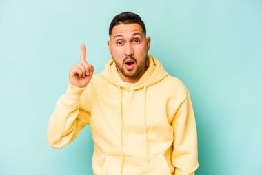 Genç İspanyol bir adam mavi arka planda izole bir fikir, ilham konsepti var.