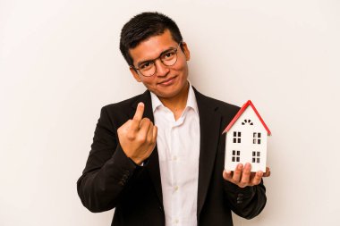 Beyaz arka planda izole edilmiş küçük bir evi tutan İspanyol genç adam seni işaret ediyor sanki davet ediyormuş gibi..