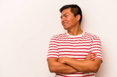 Beyaz arka planda izole edilmiş genç İspanyol adam kollarını kavuşturarak gülümsüyor..