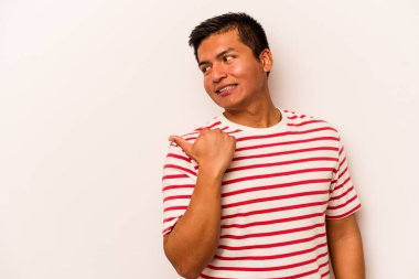 Latin kökenli genç adam beyaz arka planda izole edilmiş, başparmak uzakta, gülüyor ve kaygısız..