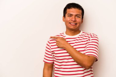 Beyaz arka planda izole edilmiş genç İspanyol adam gülümsüyor ve boş alanda bir şeyler gösteriyor..