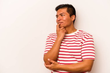 Beyaz arka planda izole edilmiş genç İspanyol bir adam rahatlamış bir şeyin fotokopi odasına baktığını düşünüyor..