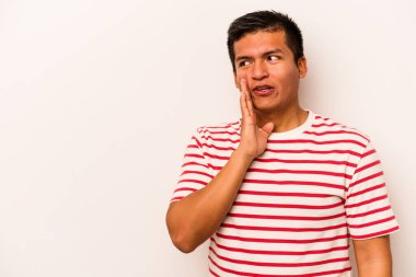 Beyaz arka planda izole edilmiş genç İspanyol bir adam gizli bir sıcak fren haberi veriyor ve yana bakıyor.