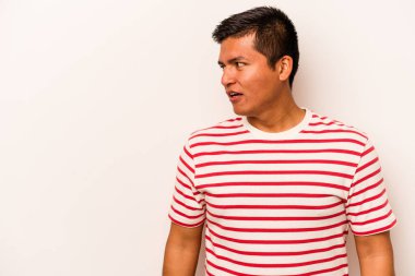 Beyaz arka planda izole edilmiş genç İspanyol adam gördüğü bir şey yüzünden şoka uğruyor..