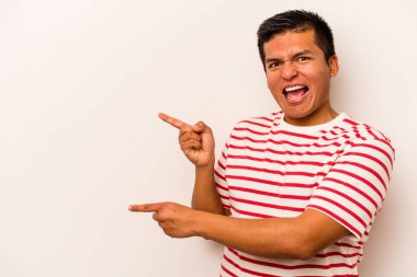 Beyaz arka planda izole edilmiş genç İspanyol adam işaret parmaklarıyla fotokopi alanını işaret ederek heyecan ve arzuyu ifade ediyor..