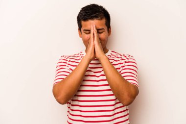 Beyaz arka planda izole edilmiş genç bir İspanyol. El ele tutuşup dua ediyor. Kendine güveniyor..