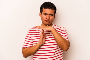 Beyaz arka planda izole edilmiş genç İspanyol bir adam bir mola hareketi gösteriyor..