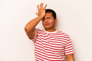 Beyaz arka planda izole edilmiş genç İspanyol bir adam bir şeyi unutuyor. Alnına avuç içi ile vuruyor ve gözlerini kapıyor..