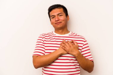 Beyaz arka planda izole edilmiş genç İspanyol bir adam, dost canlısı bir ifadeye sahip, avuçlarını göğsüne bastırıyor. Aşk konsepti.