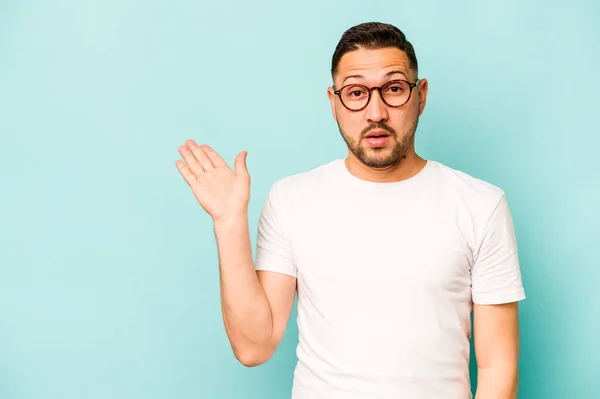 Young Hispanic Man Isolated Blue Background Impressed Holding Copy Space — Stock Photo, Image