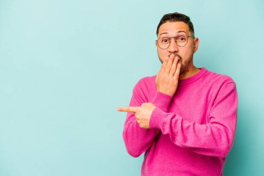 Mavi arka planda izole edilmiş genç bir İspanyol yan tarafı gösteriyor.